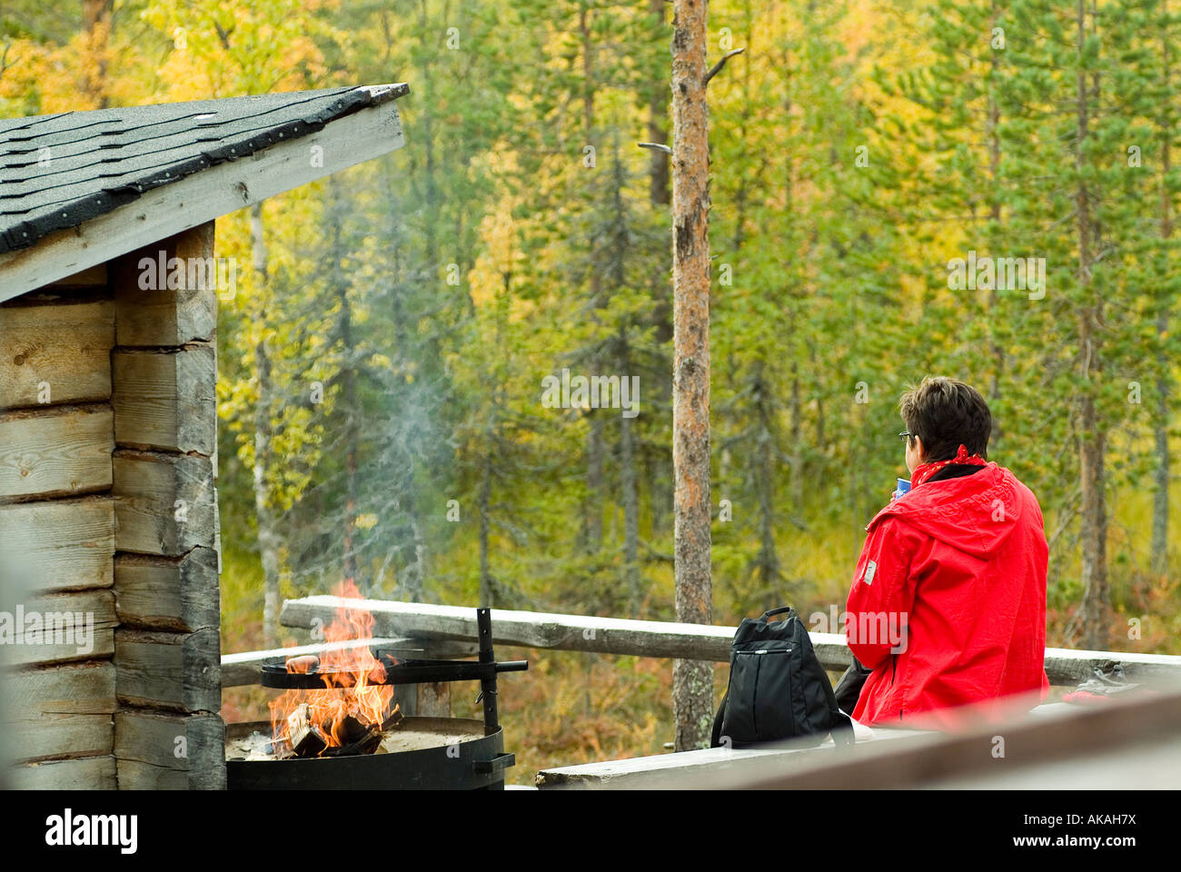 woman at a block cabin refugee with fire place for a pause at a trecking route Stock Photo