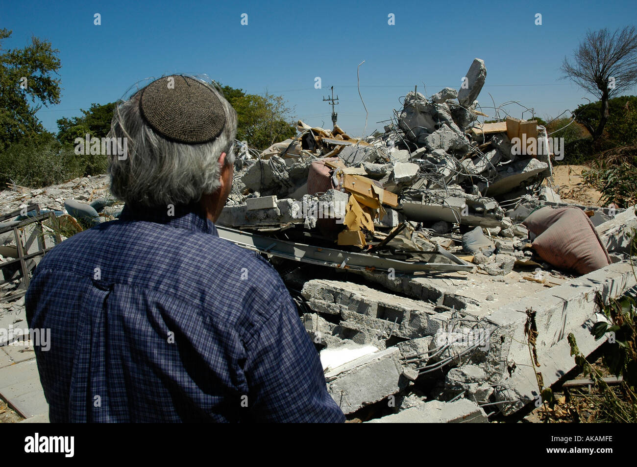 A former Israeli settler looks at mounds of rubble of his demolished house in what used to be the Gaza Strip settlement of Neve Dekalim Stock Photo