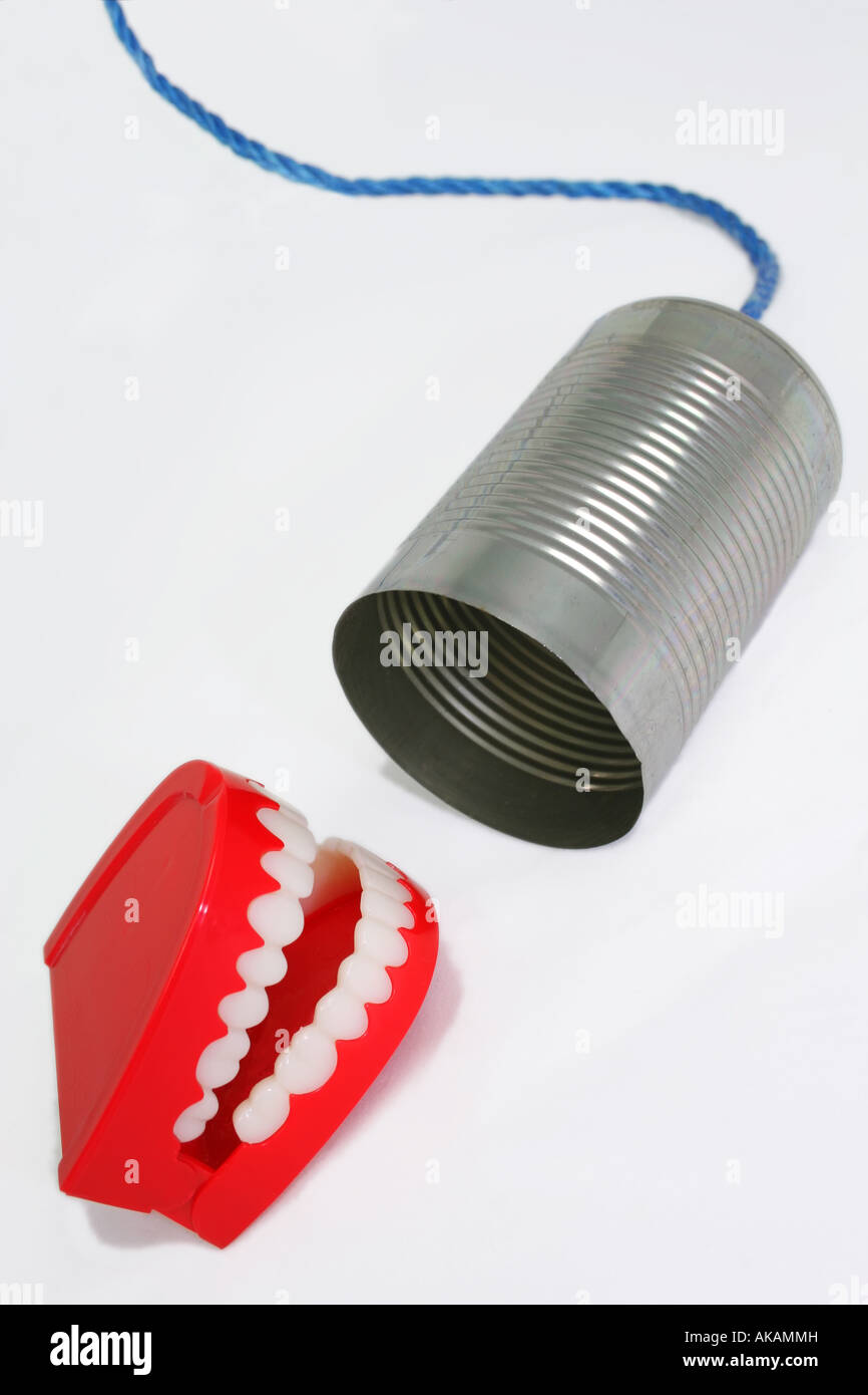 novelty teeth talking into tin can Stock Photo