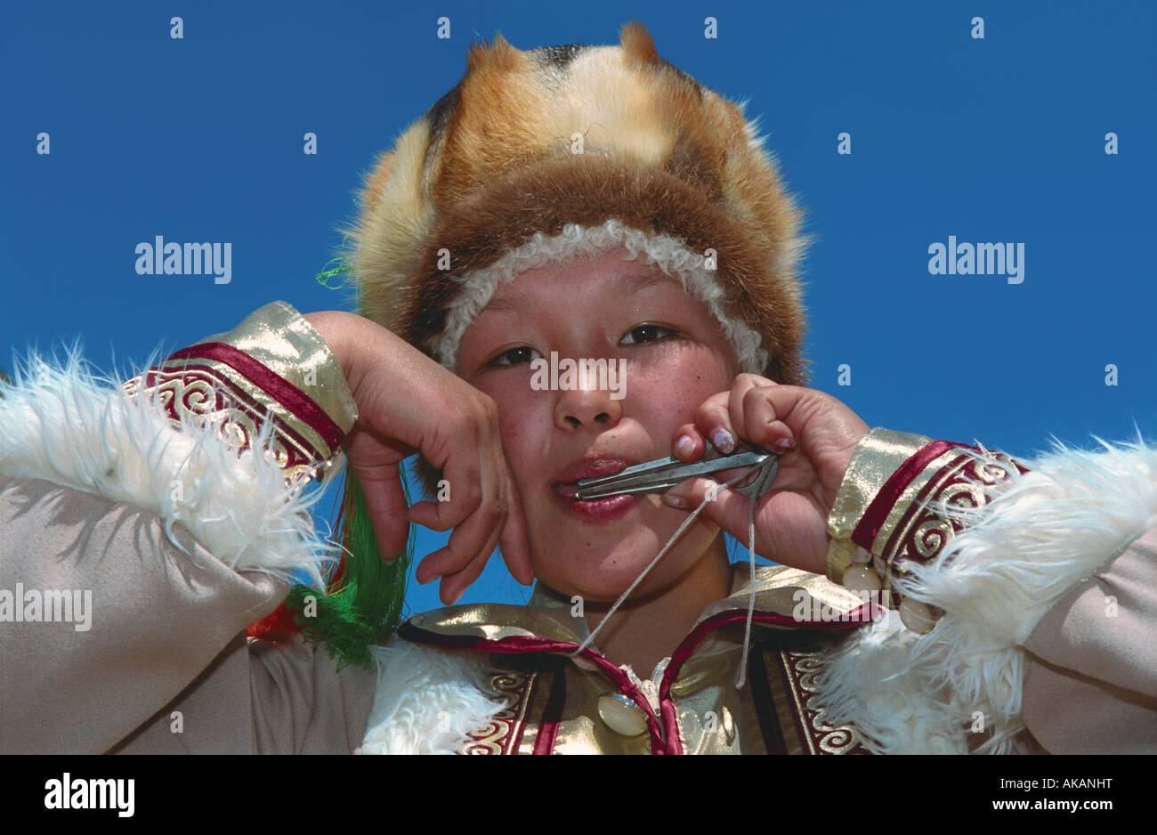 Portrait of young girl playing national Altaic instrument komus. El-Oiyn - national festival of Altaic people. Russia Stock Photo