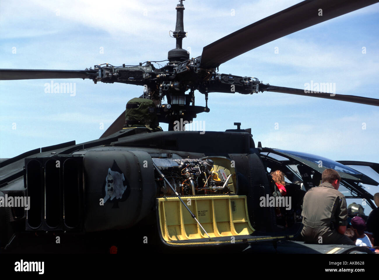 A close up view of a military helicopter or chopper shows complex mechanisms and four singular blades with a bright yellow panel Stock Photo
