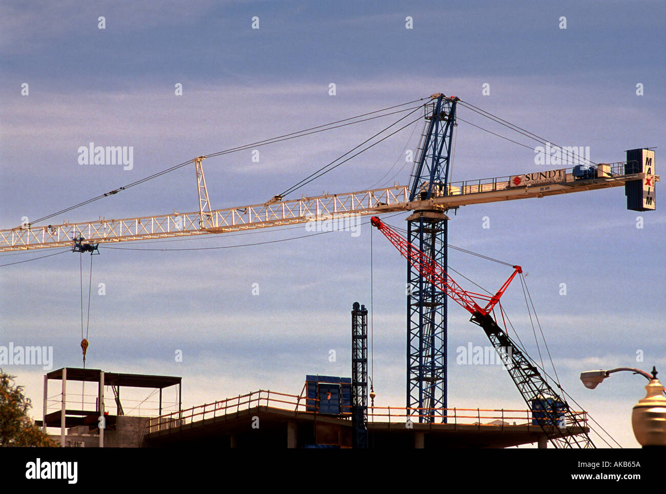 Construction Derrick works with cranes to build hi rise condominiums
