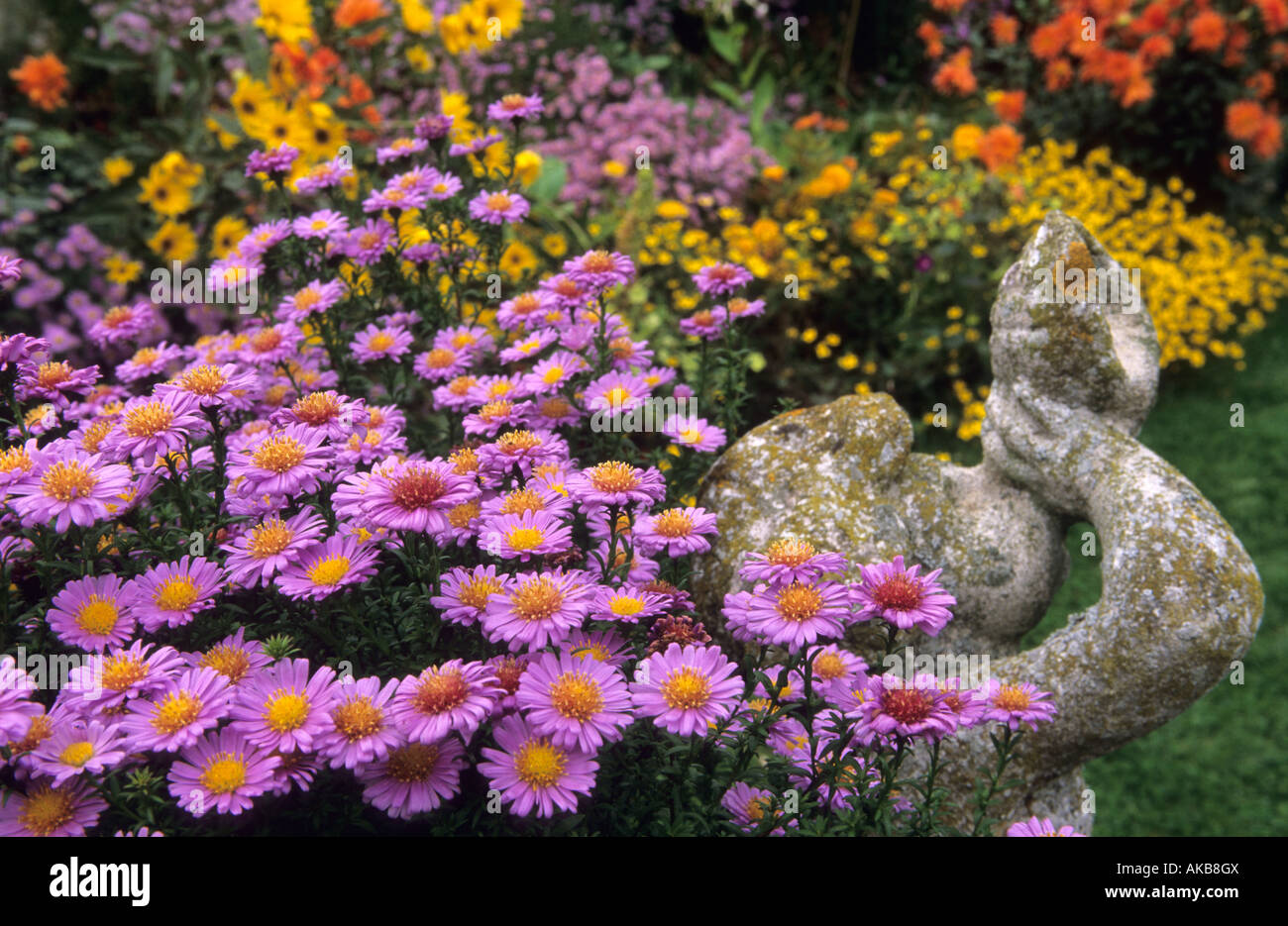 Maison Rose Giverny France contrasting colourful autumn flower combinations figurative statue Asters Dahlia Helianthemum Stock Photo