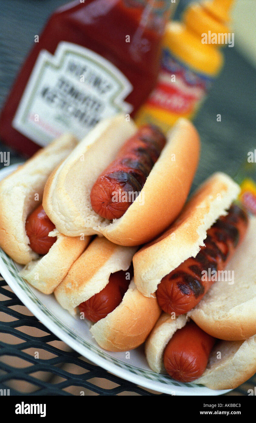 Pile of hotdogs with ketchup and mustard in background Stock Photo