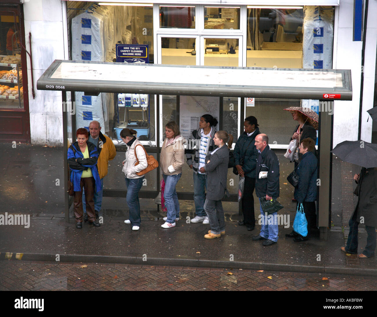 People waiting at a bus stop in London Uk. Stock Photo