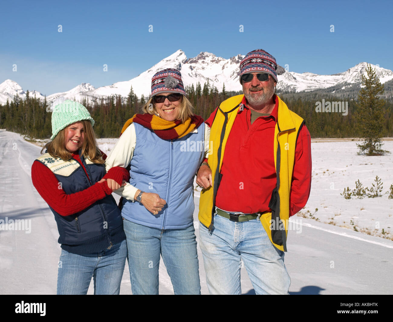 A family of husband wife and daughter enjoy a winter day in the Cascade ...