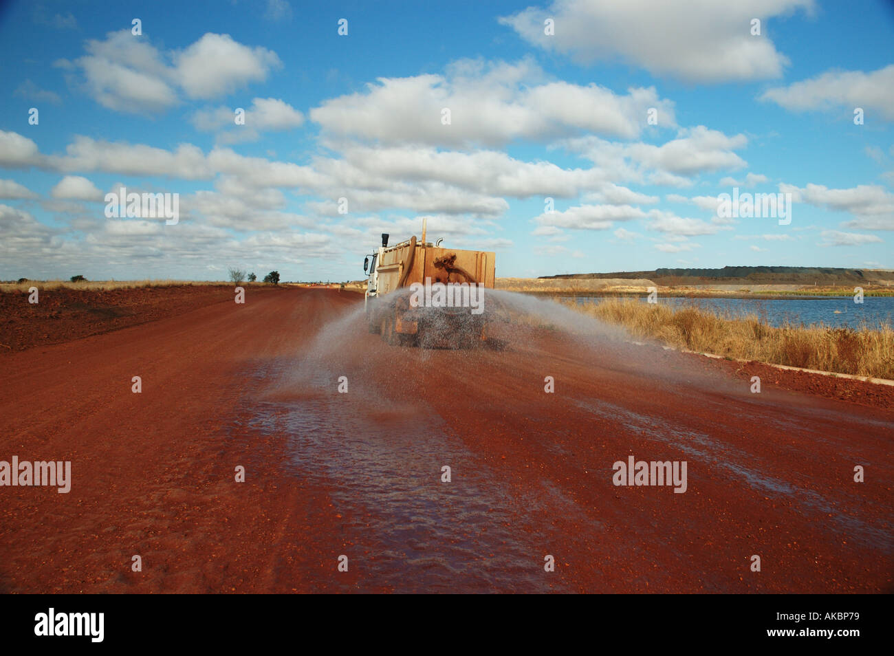 Water truck spraying to suppress dust on coal mining site access road ...