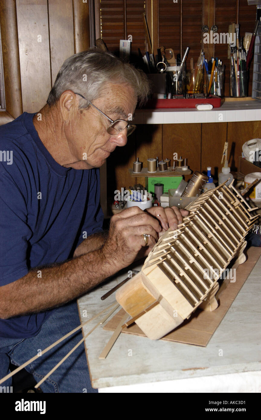 Elderly map working on ship model Stock Photo