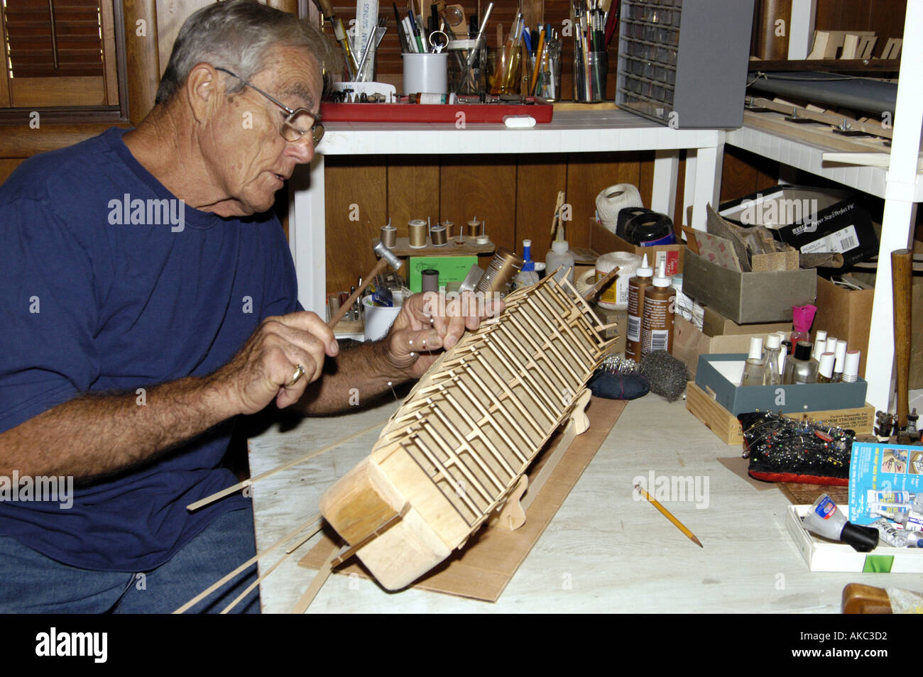 Elderly man working on ship model Stock Photo