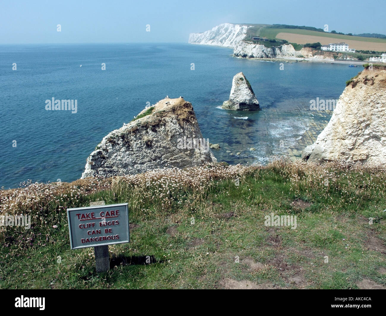 Cliff edge warning sign on top of soft chalk cliffs along Freshwater Bay Isle of Wight Stock Photo