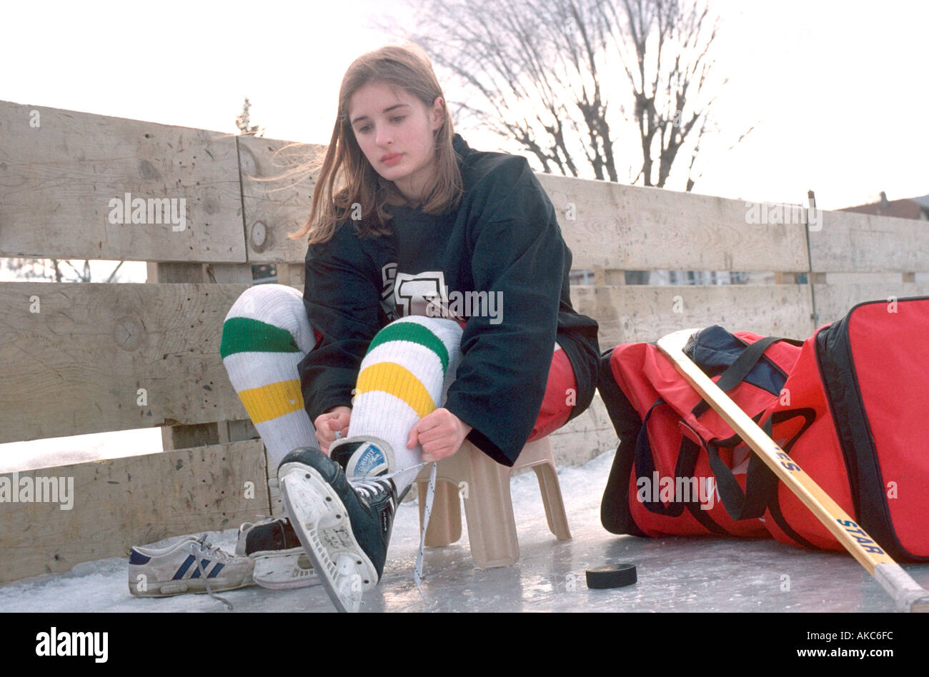 Female hockey player age 14 lacing skates for game. St Paul Minnesota