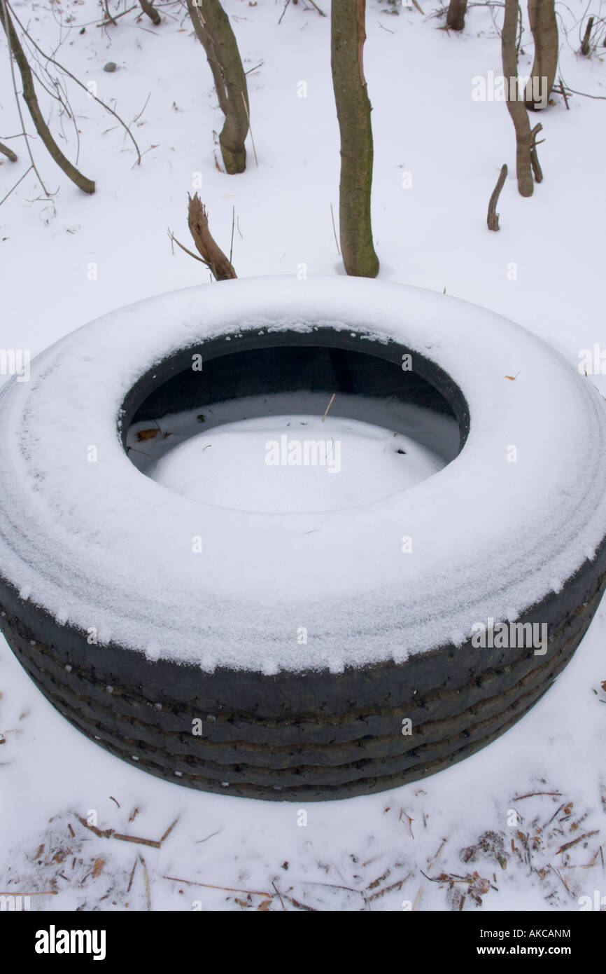 Thrown away old truck rubber tire in natural Winter environment Stock Photo