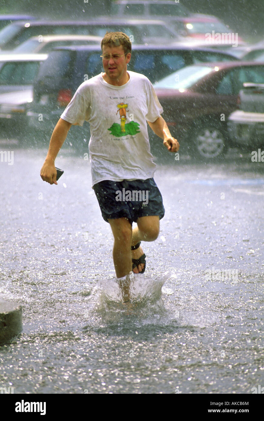 A man runs through a summer downpour Stock Photo