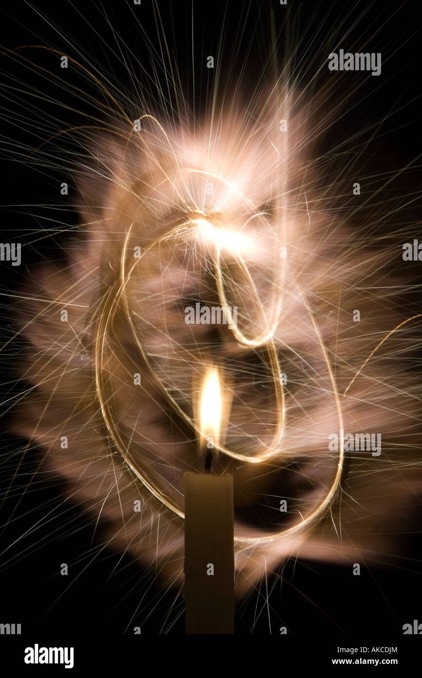 Candle light with circular light spark trails at night Stock Photo