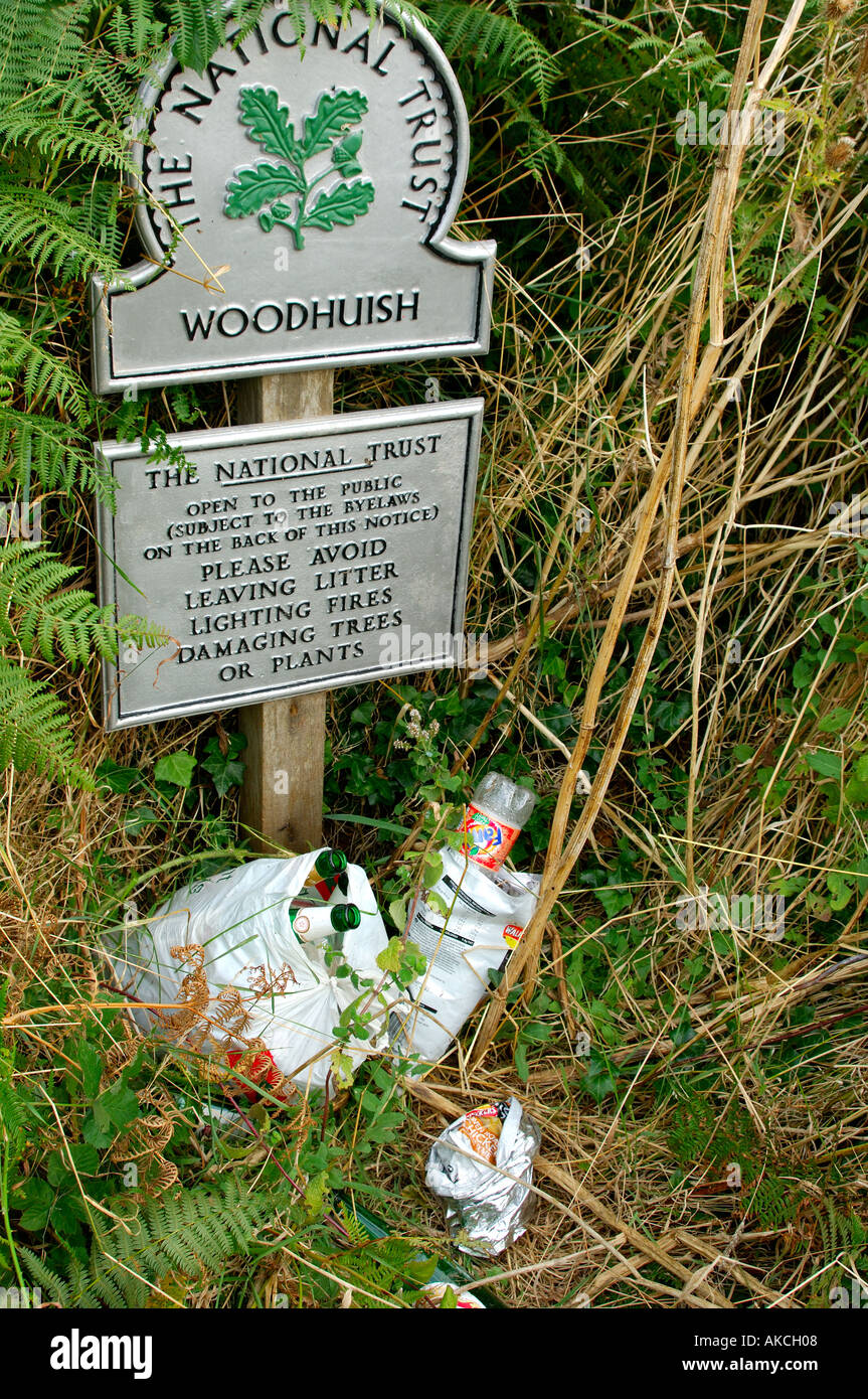 Pile of rubbish left below sign saying please avoid leaving rubbish showing the irresponsible attitude of many people today Stock Photo