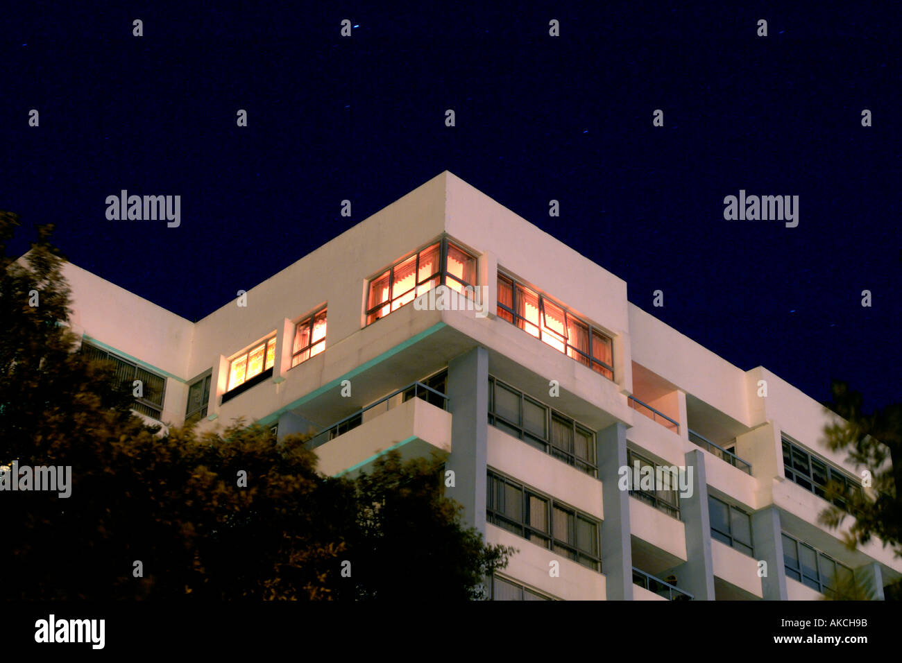 Corner of art deco style hotel with single room illuminated at night Stock Photo