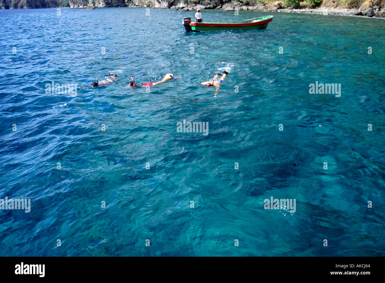 Three people snorkelling off the coast of St Lucia in the Caribbean ...