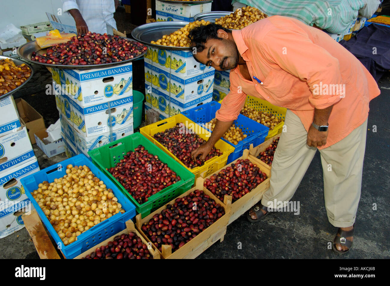 Indian man selling fresh Omani dates at vegetable market Abu Dhabi UAE Stock Photo