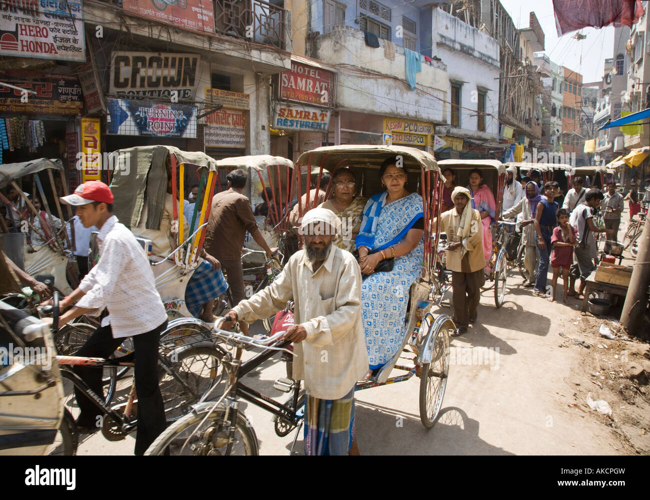 Varanasi Rickshaws A long line of rickshaws in crowded, narrow town centre street ...