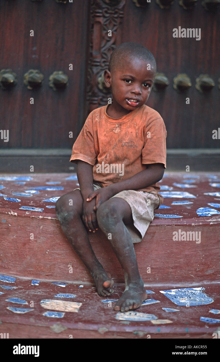 Zanzibari boy sitting on stone steps Stone Town Zanzibar Tanzania East Africa Stock Photo