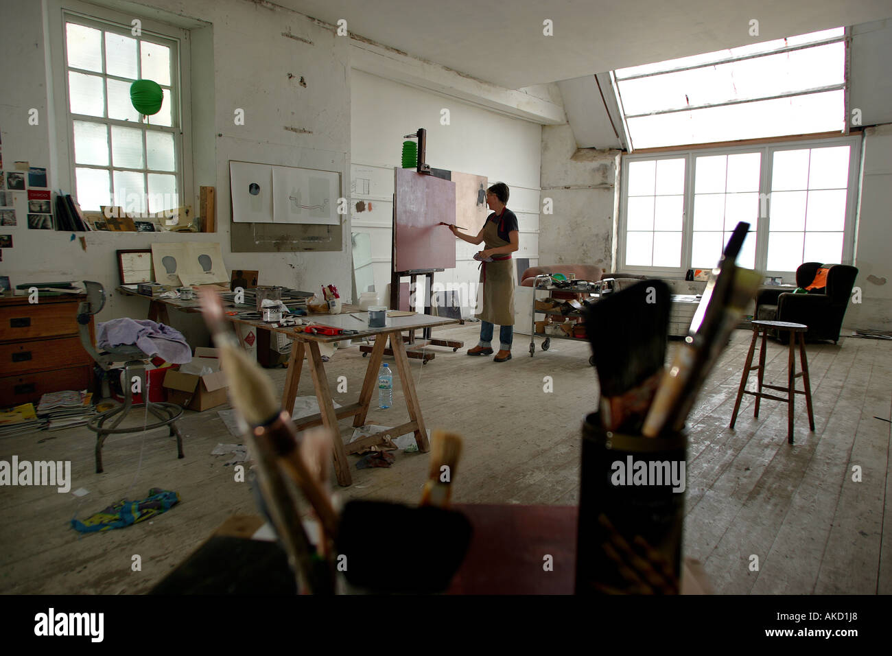 A painter at work in one of the St Ives artists studios on Porthmeor Beach in Cornwall, England, UK Stock Photo