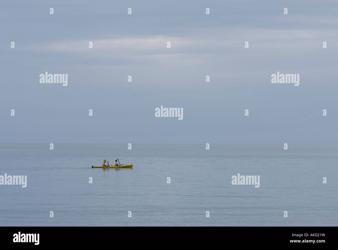 two men in a yellow canoe on the pacific ocean at hervey bay queensland ...