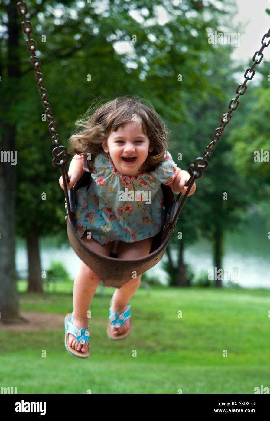 Ecstatic 3 Year Old Girl On Playground Swing Stock Photo