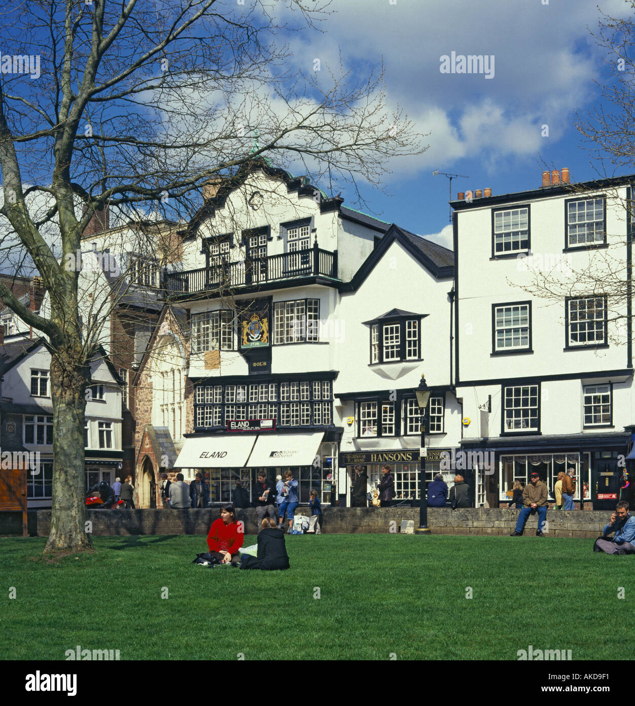 Old black and white buildings with paned sash windows and coat of arms dated 1596 in Cathedral Close Exeter Stock Photo