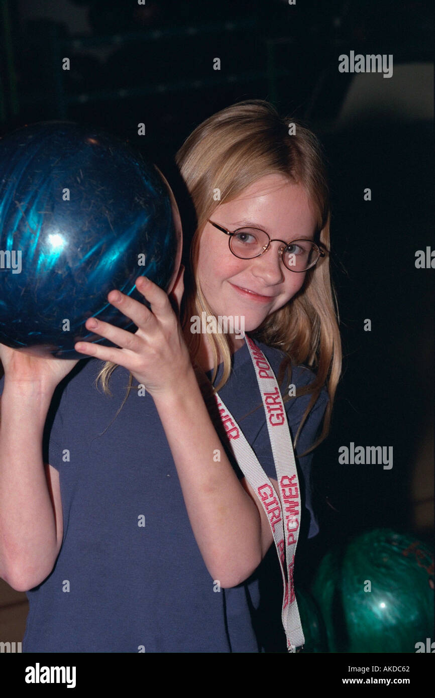 Teen girl age 13 holding bowling ball at youth center outing. Minneapolis Minnesota USA Stock Photo