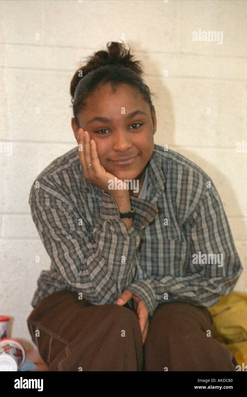 Black teen age 15 smiling resting chin on hand at community youth center. St Paul Minnesota USA Stock Photo