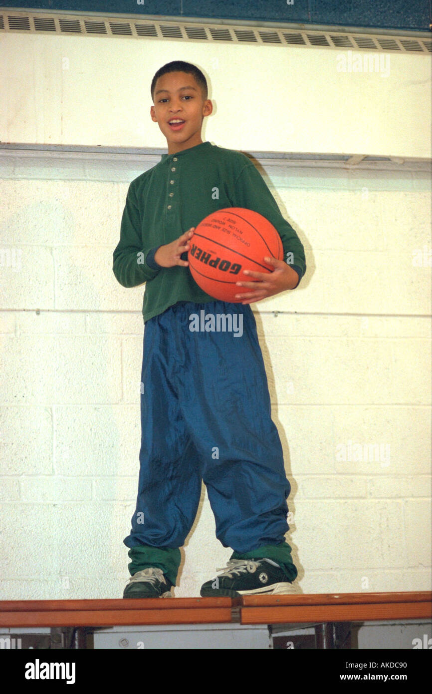 Black teen age 13 holding basketball at community youth center. St Paul Minnesota USA Stock Photo