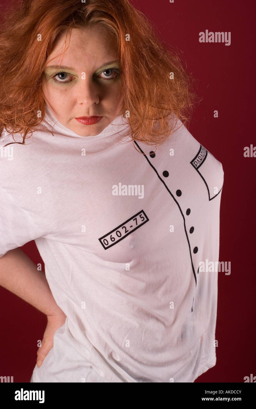 Portrait of a red haired woman in white shirt on a red background Stock Photo