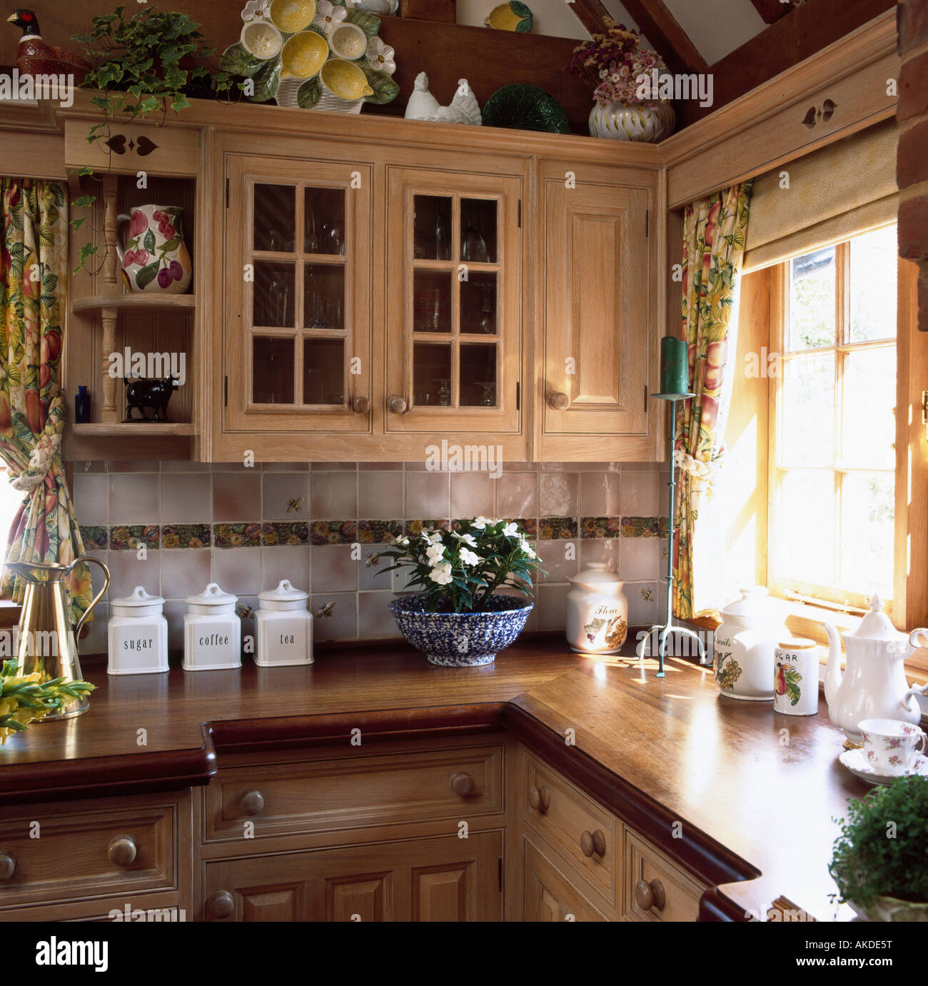 Corner of country kitchen with wooden worktops and cupboards Stock Photo