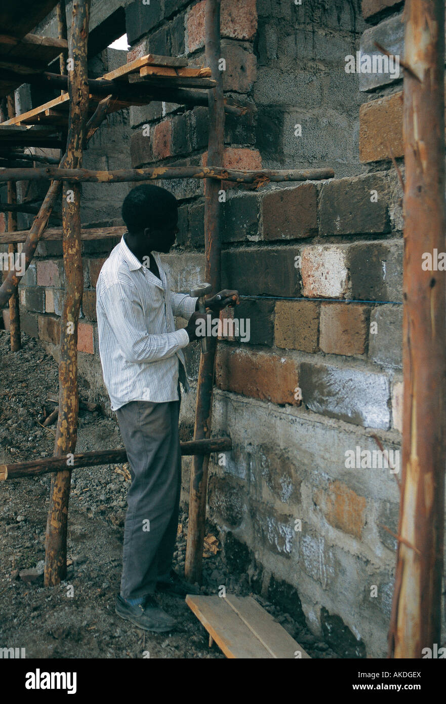 Young black African man or builder working on simple house of brick and concrete blocks Nakuru Kenya East Africa Stock Photo