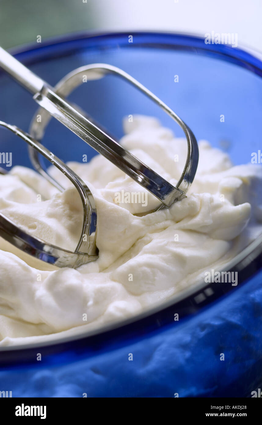Whipped cream with beaters in a bowl Stock Photo