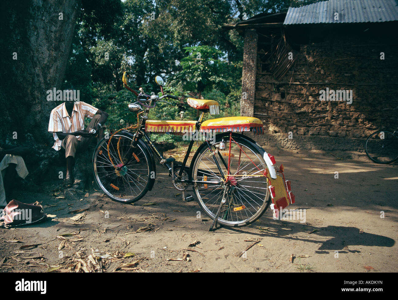 African man with his bicycle taxi waiting under a tree for customers in Malindi coast of Kenya East Africa Stock Photo