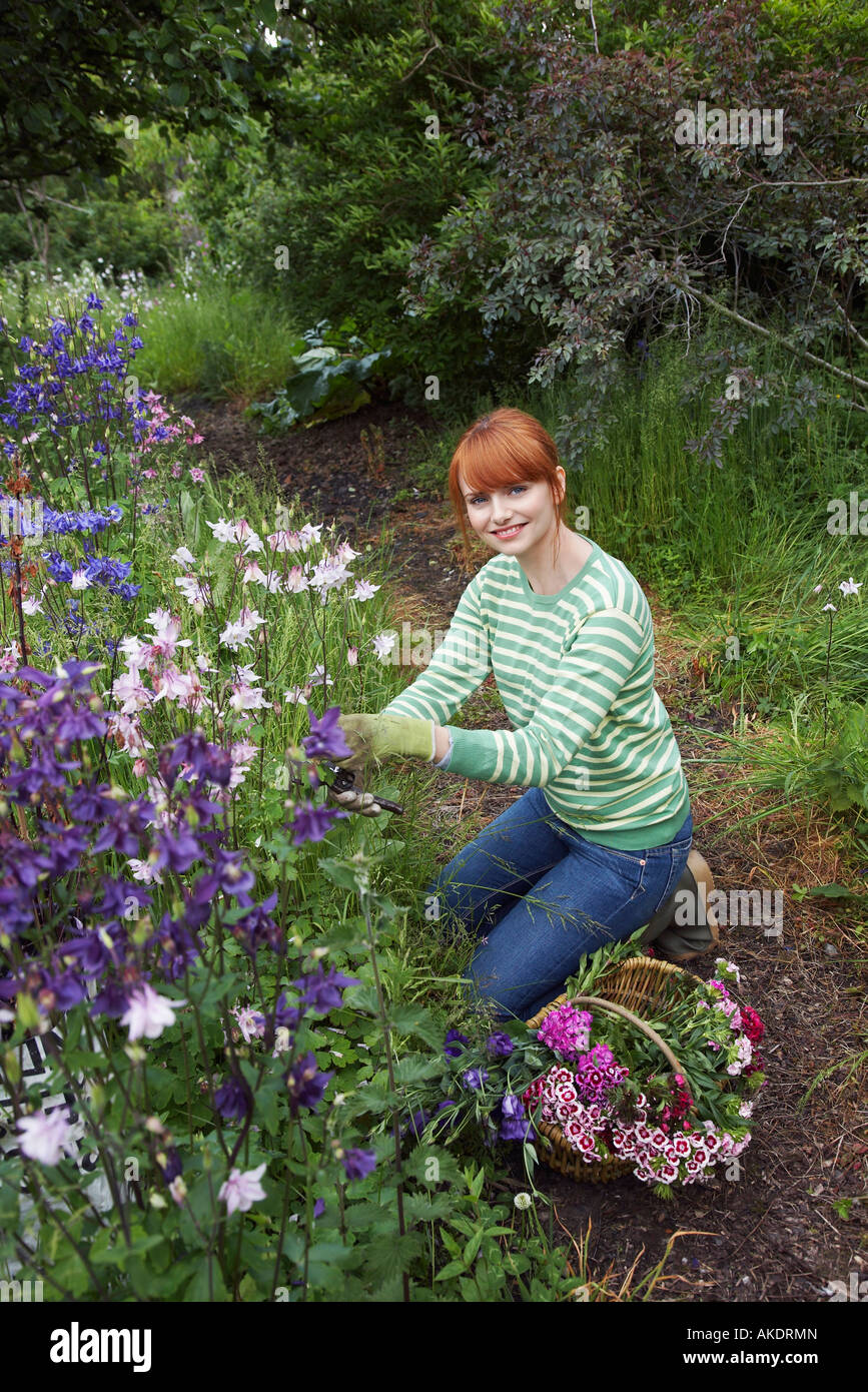 Woman picking flowers in garden, portrait Stock Photo Alamy