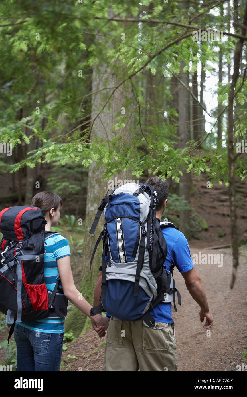 Couple holding hands, walking in forest Stock Photo - Alamy