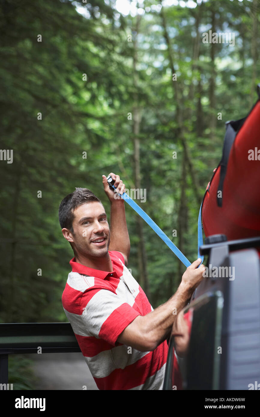 Man tying kayak on car roof, in forest Stock Photo Alamy