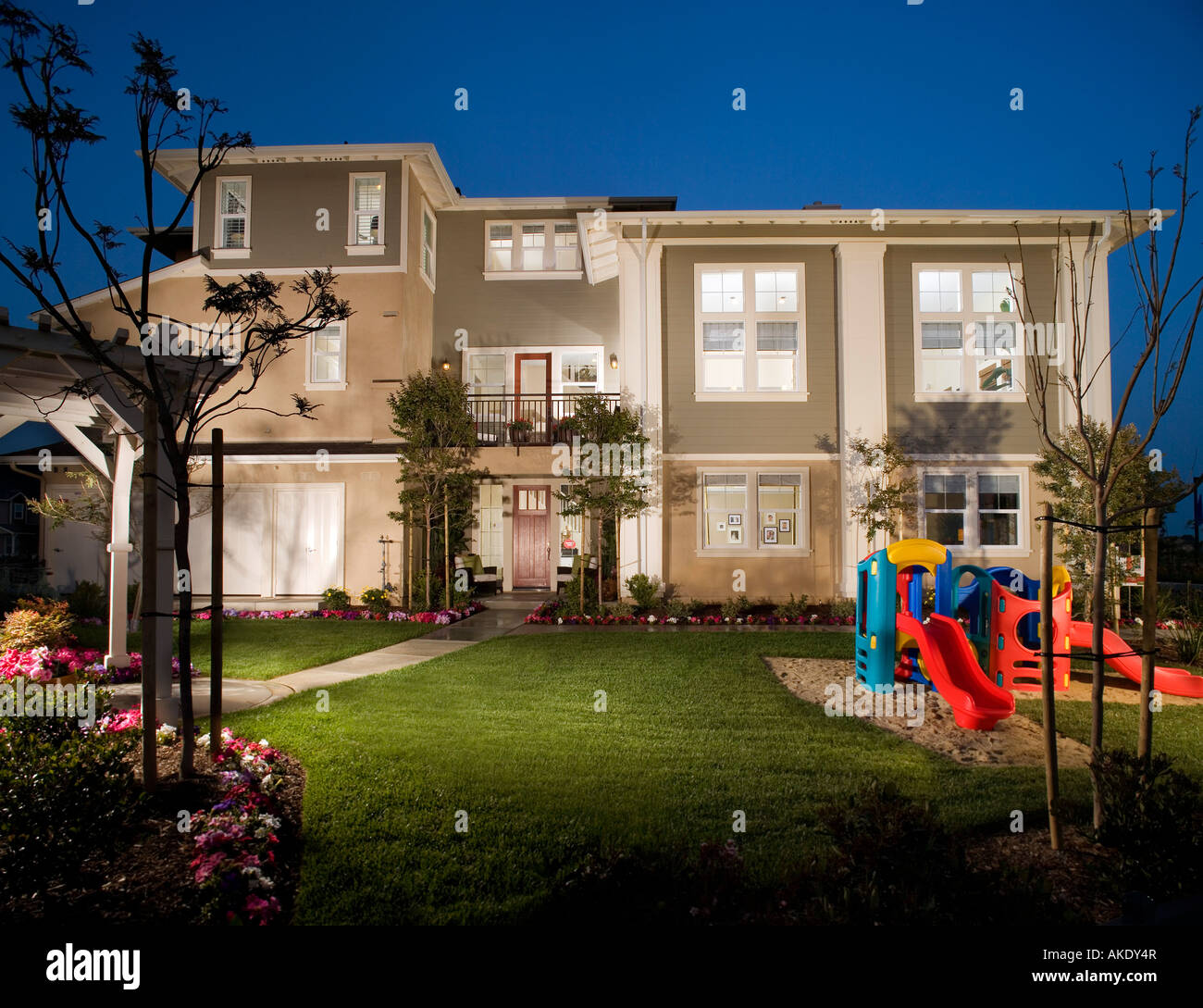 Exterior of attached homes in the evening with playground Stock Photo ...