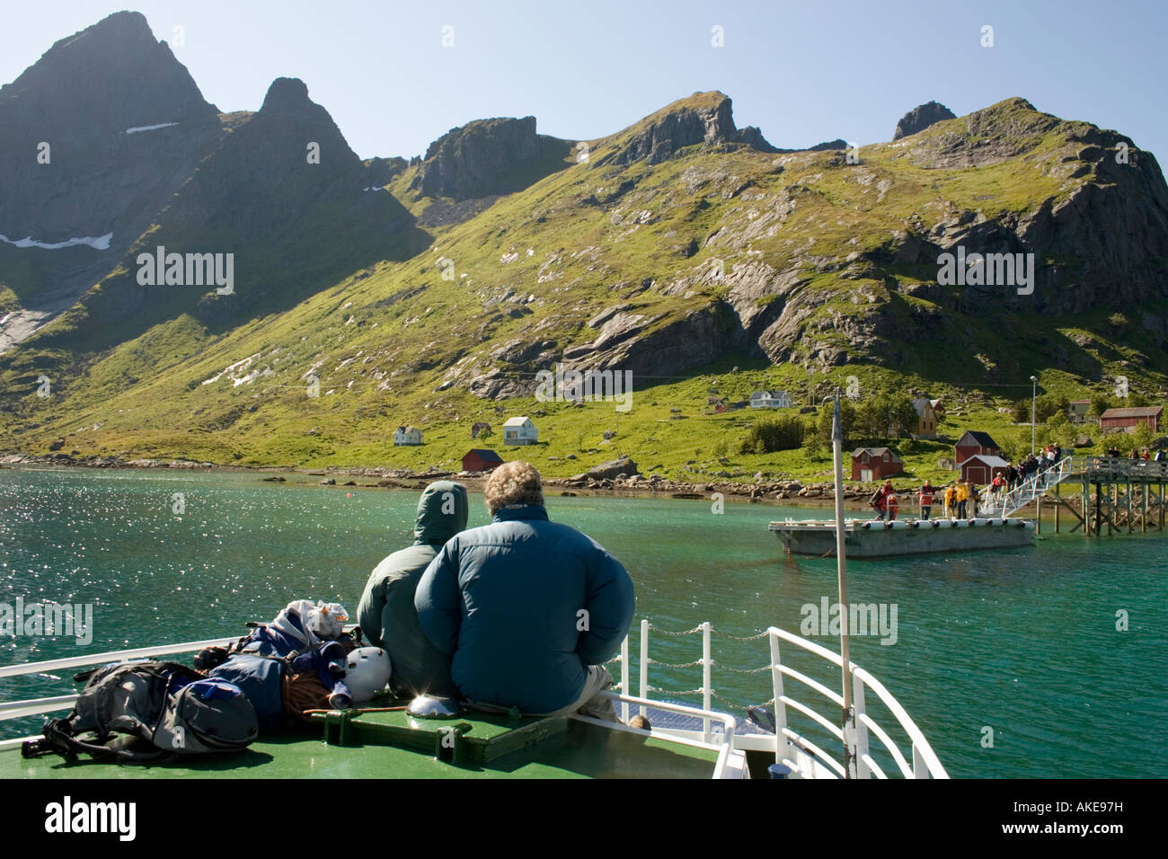 Two passengers sit on the prow of the mail ferry on its journey around