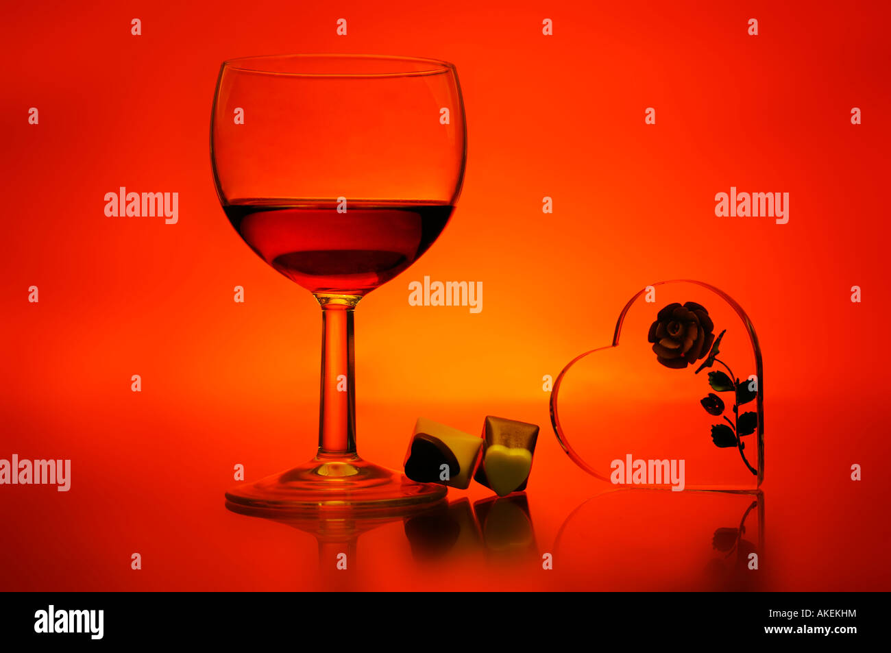 Glass of wine and chocolates on a colorful background with single rose Stock Photo
