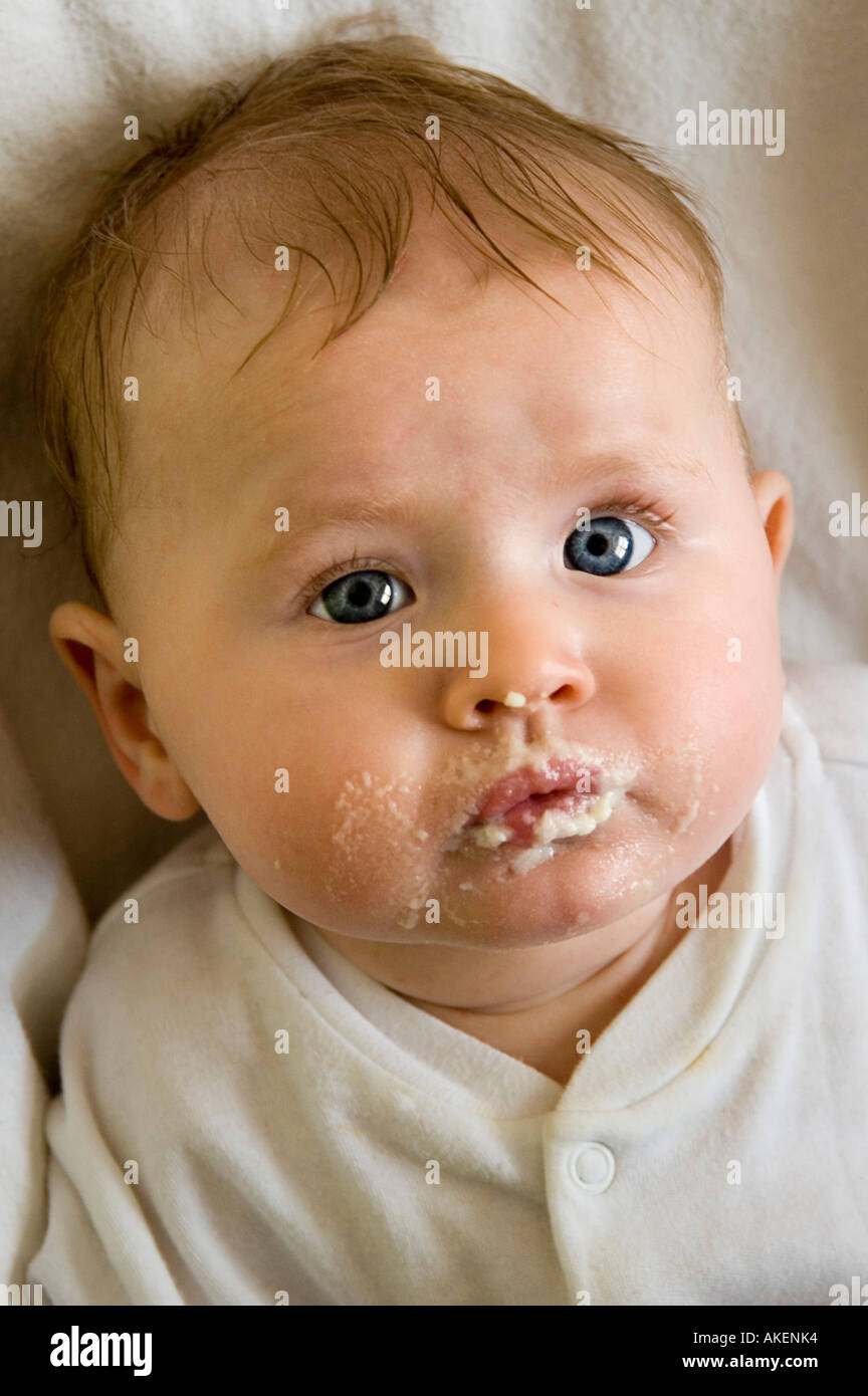 young baby girl with food on her mouth after eating Stock Photo Alamy