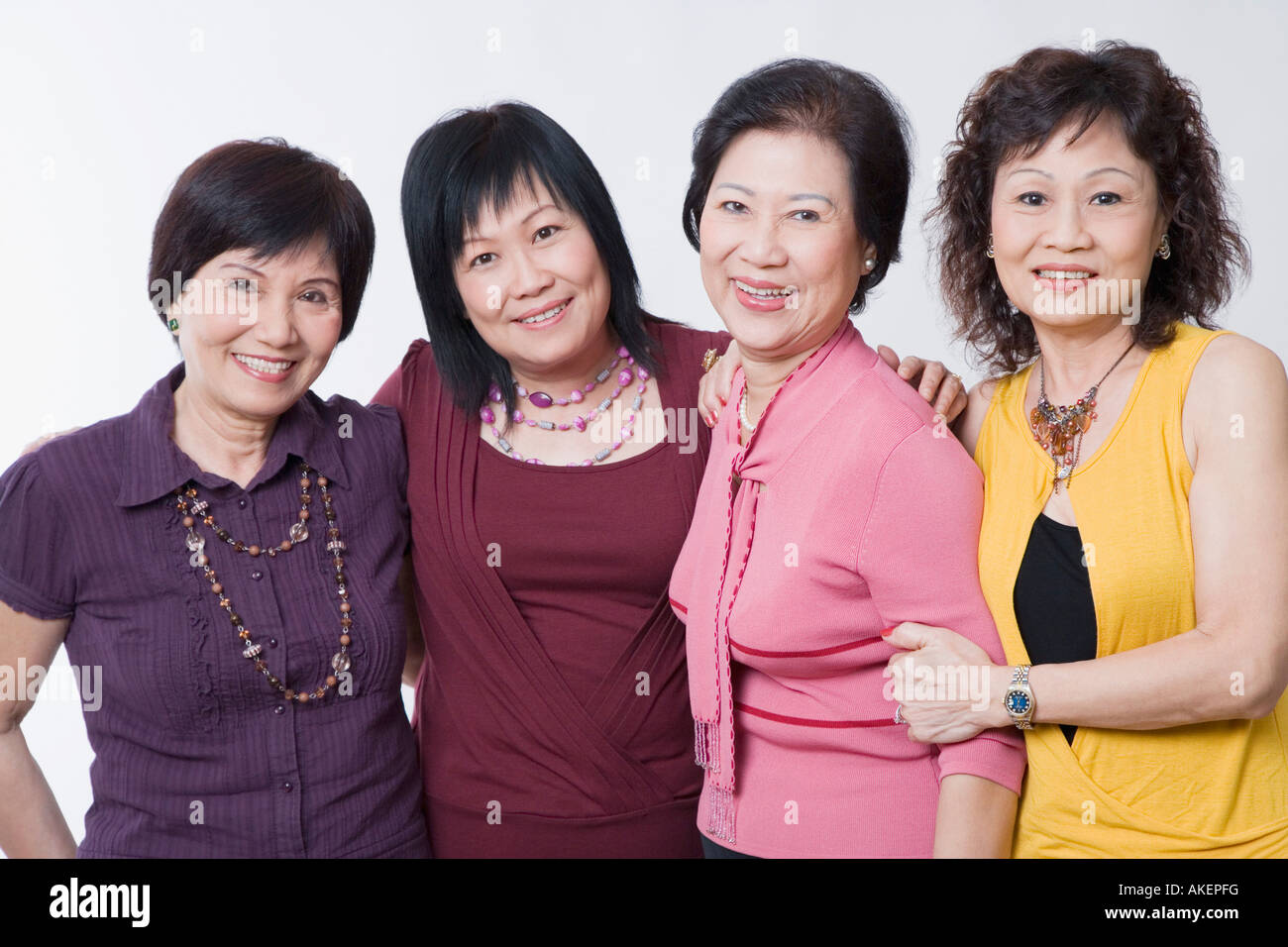 Portrait of three senior women and a mature woman standing together and ...