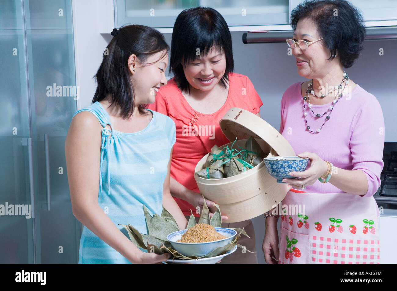Senior woman with her daughter and granddaughter in a kitchen Stock Photo