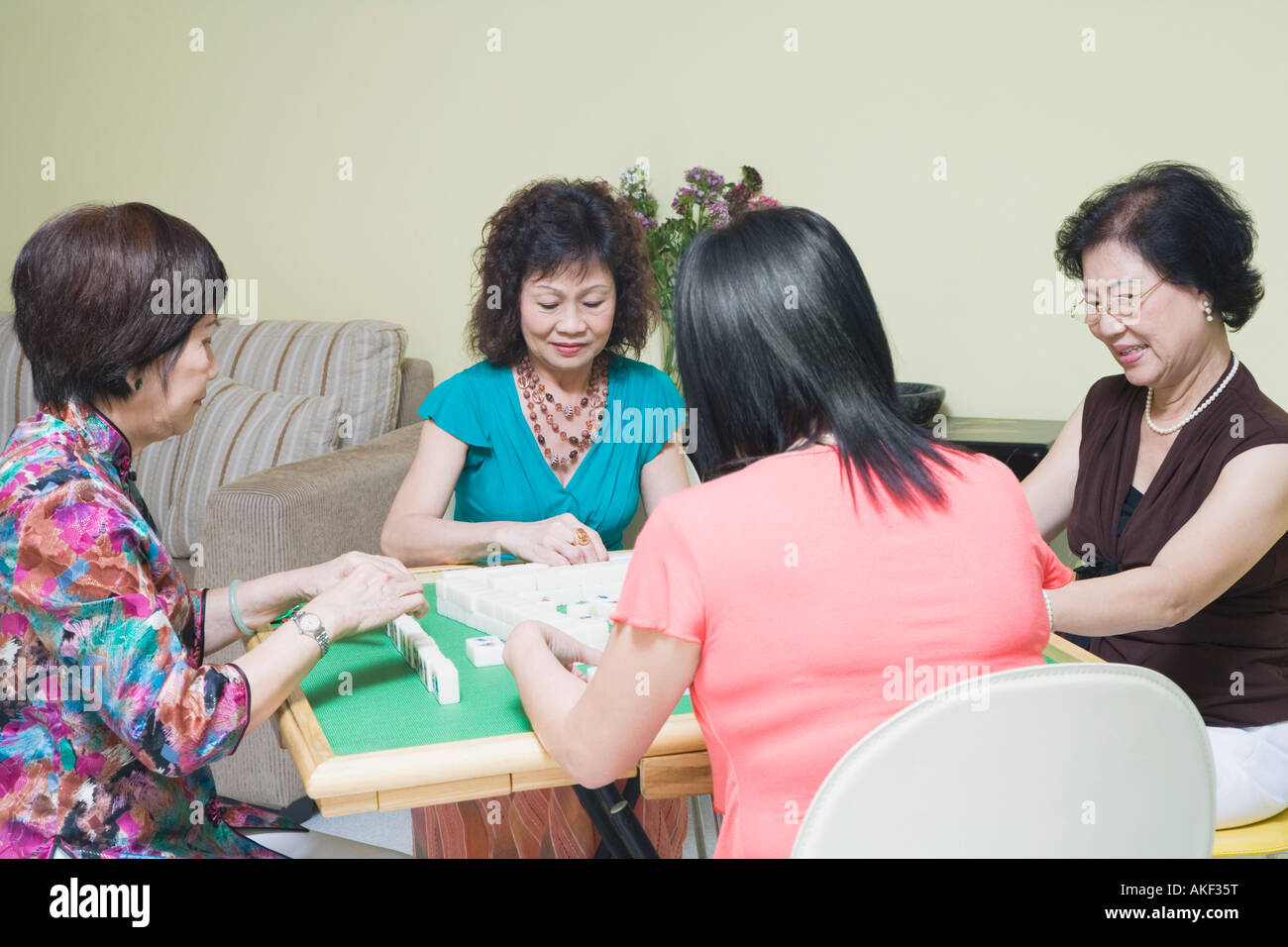 Three senior women and a mature woman playing mahjong Stock Photo