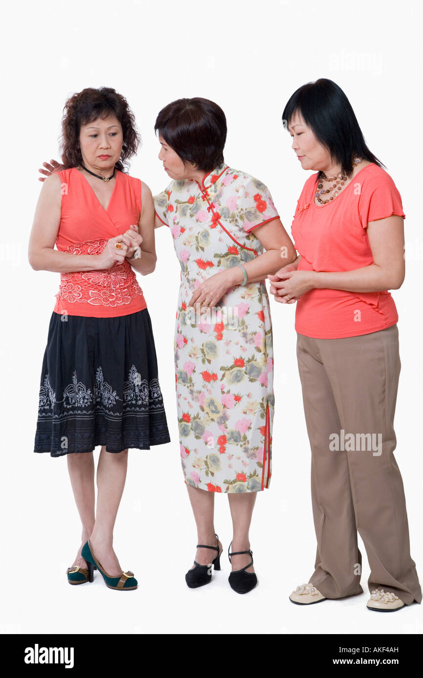 Two senior women and a mature woman standing together and talking Stock Photo