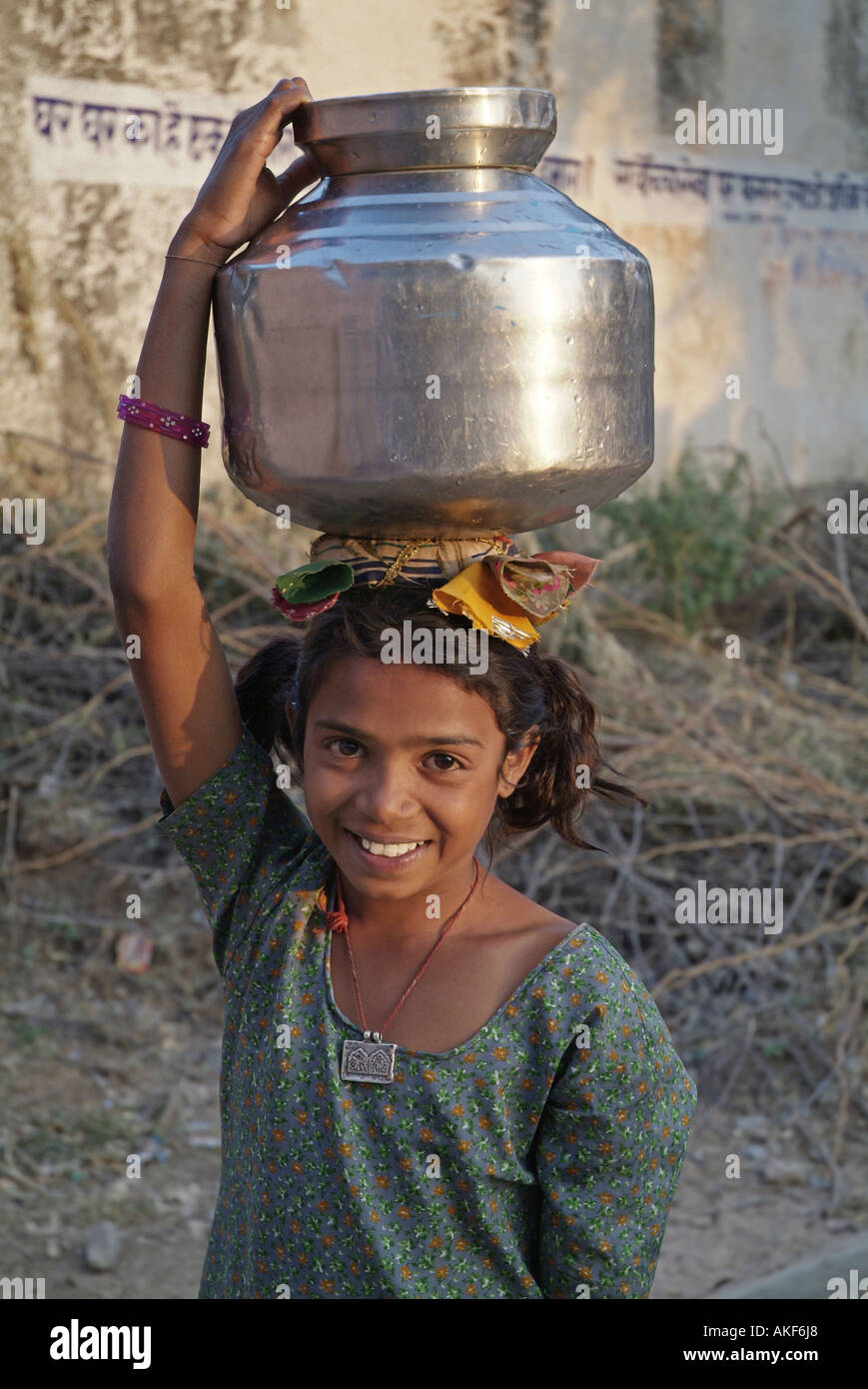 Girl carrying a water jug on her head in Rajasthan India Stock Photo