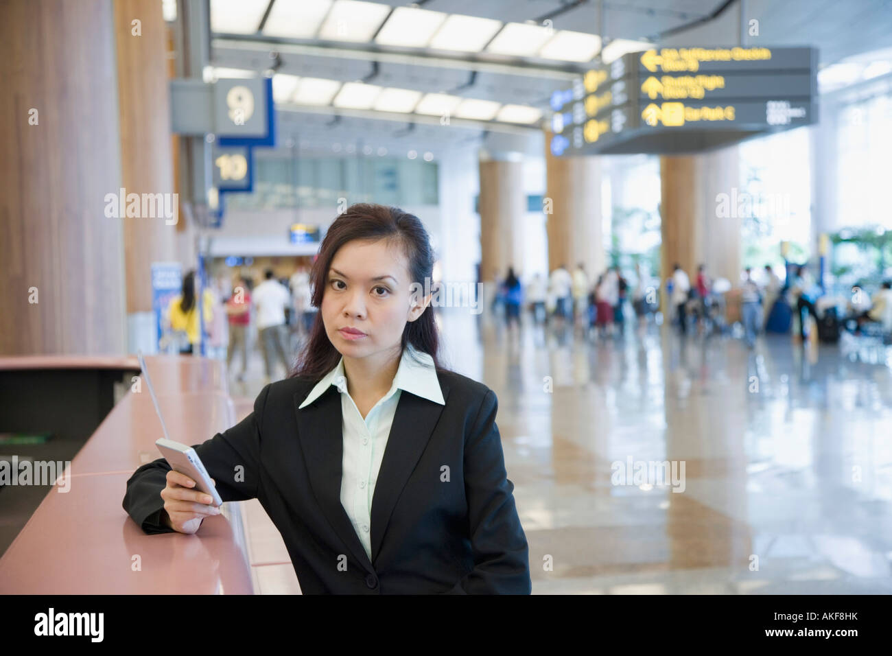 Portrait of a businesswoman using a hand held device at an airport Stock Photo