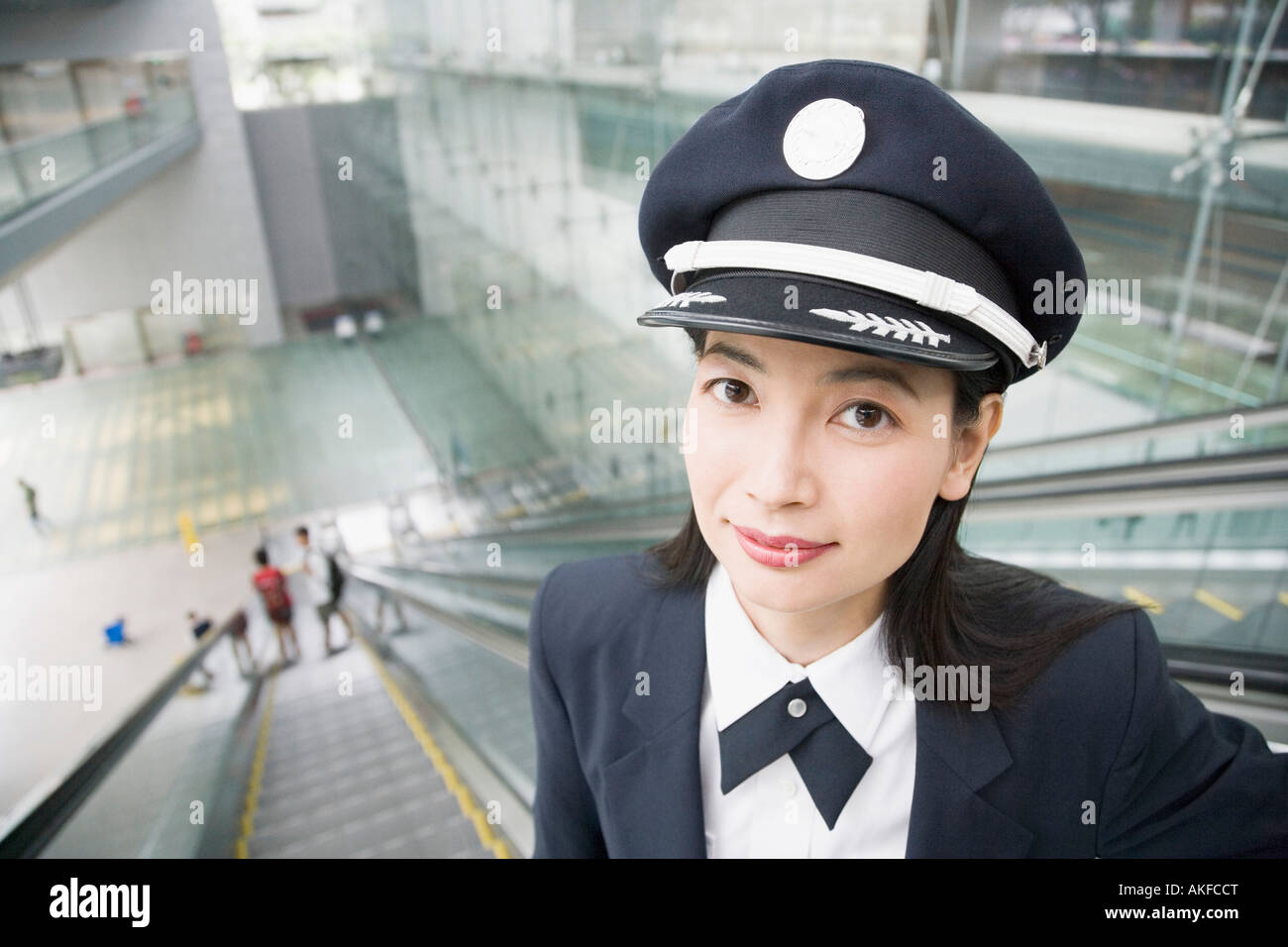 Portrait of a female pilot standing on an escalator Stock Photo